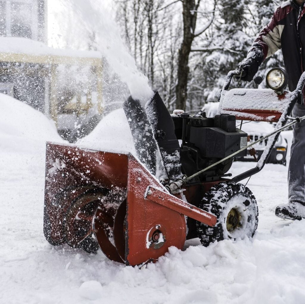 Senior man using snowblower after a snowstorm royalty free image 1676315535